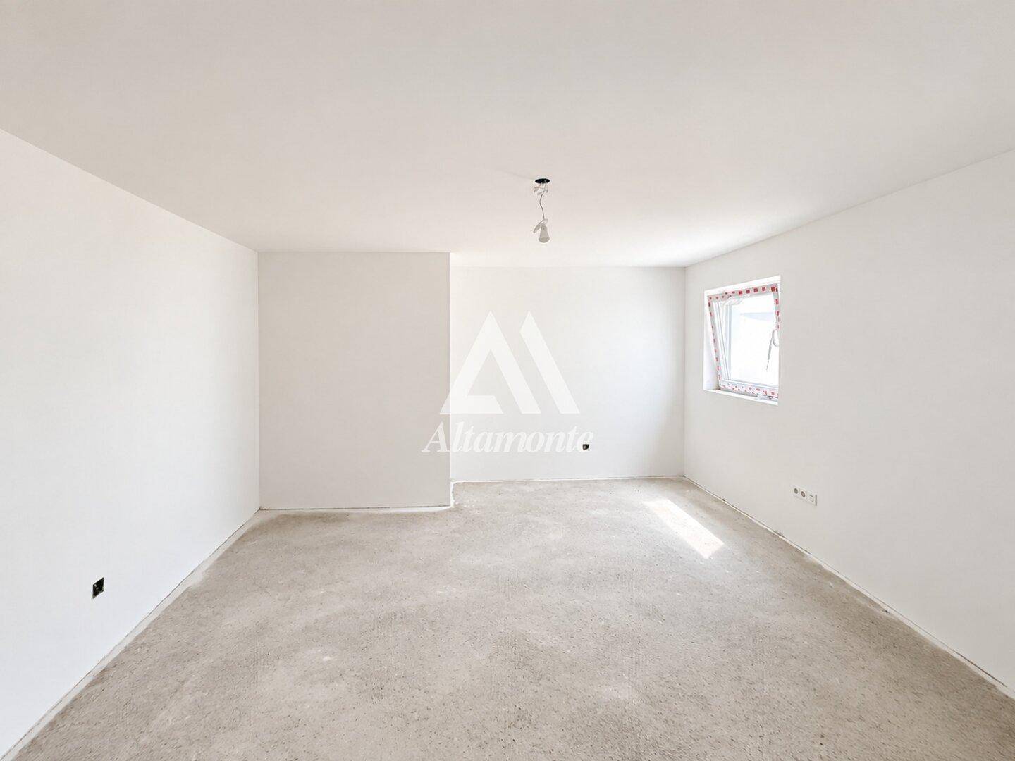 Unmöbliertes Zimmer im Rohbau mit Betonboden und einem Fenster, bereit für den Ausbau.