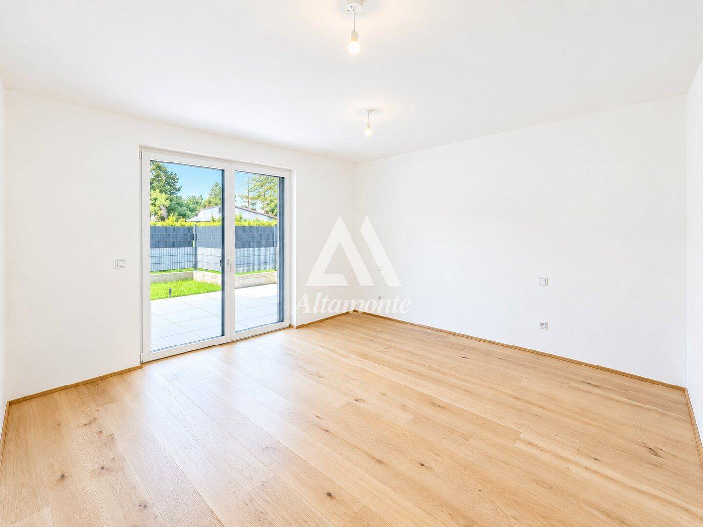 Heller Wohnraum mit Holzboden und großer Schiebetür, die direkten Zugang zum Garten ermöglicht.