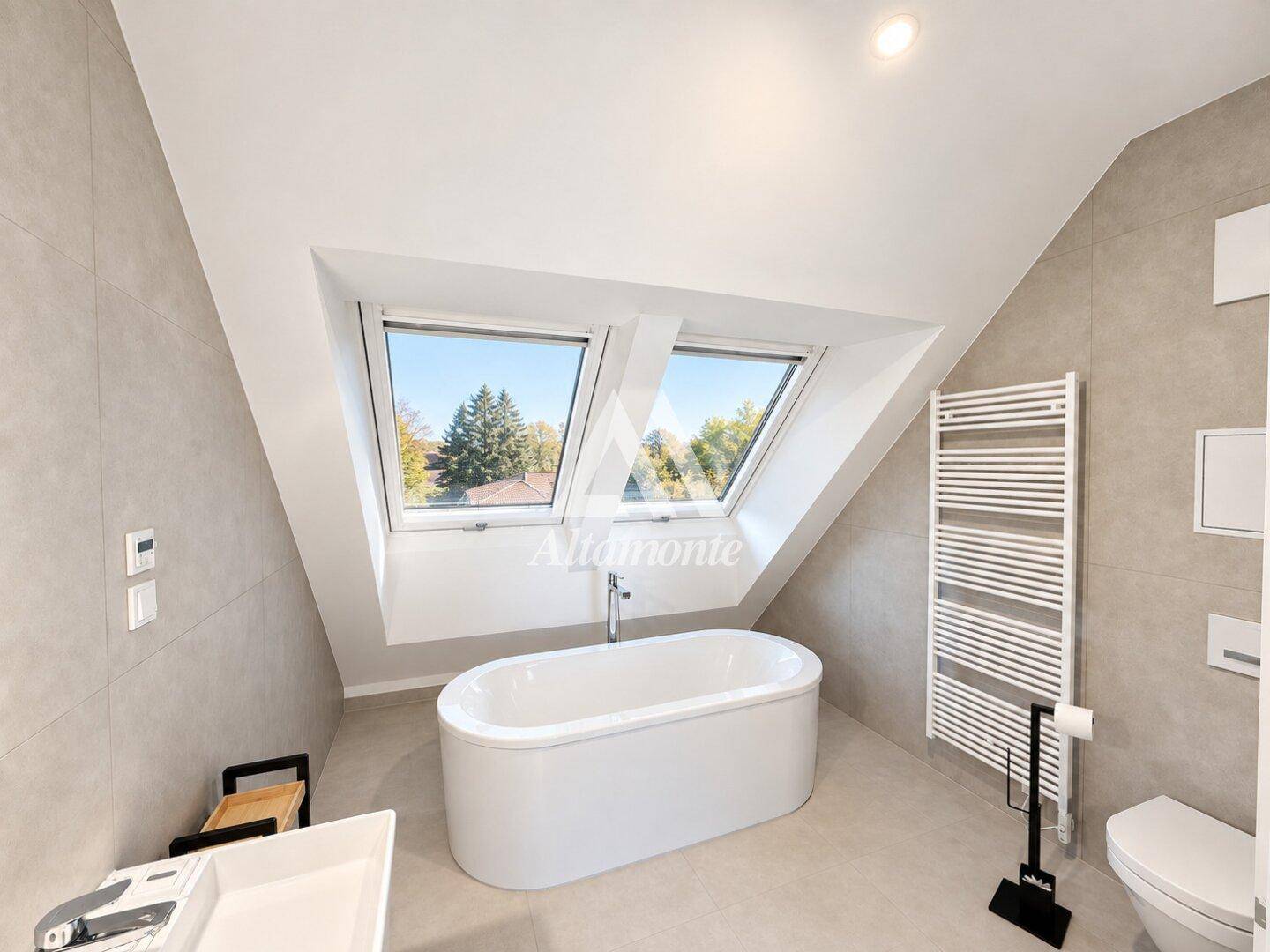 Modernes Badezimmer mit freistehender Badewanne, Dachfenstern und beheiztem Handtuchhalter.