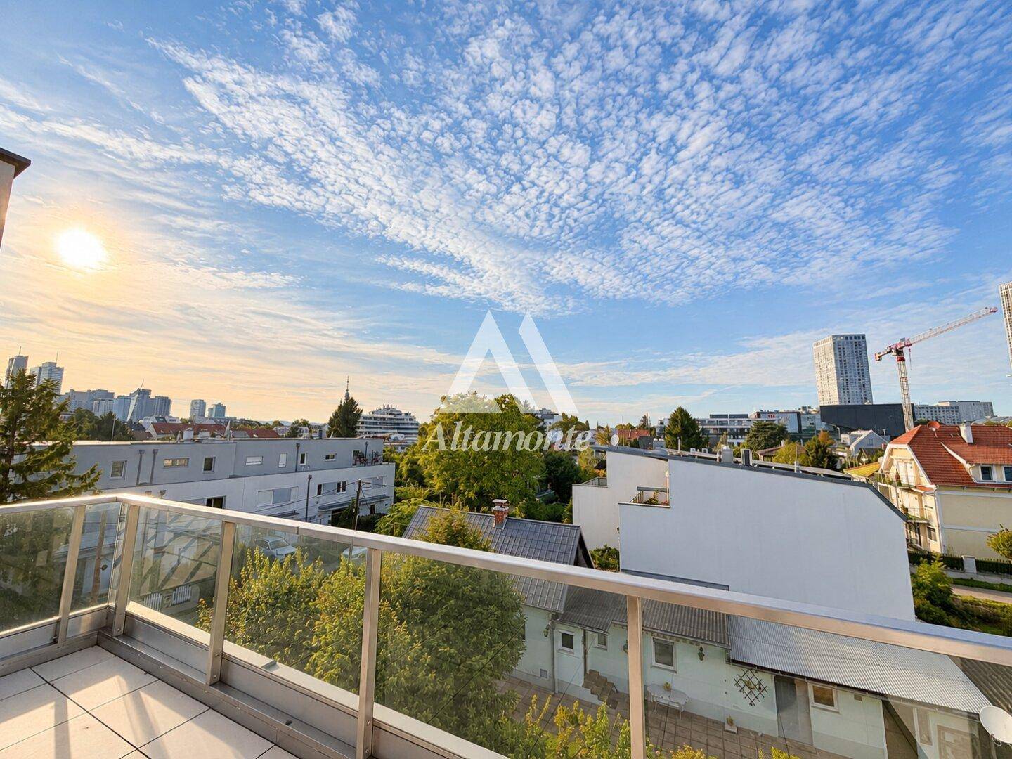 Sonniger Balkon mit Panoramablick auf die Stadt und die umliegende grüne Landschaft.