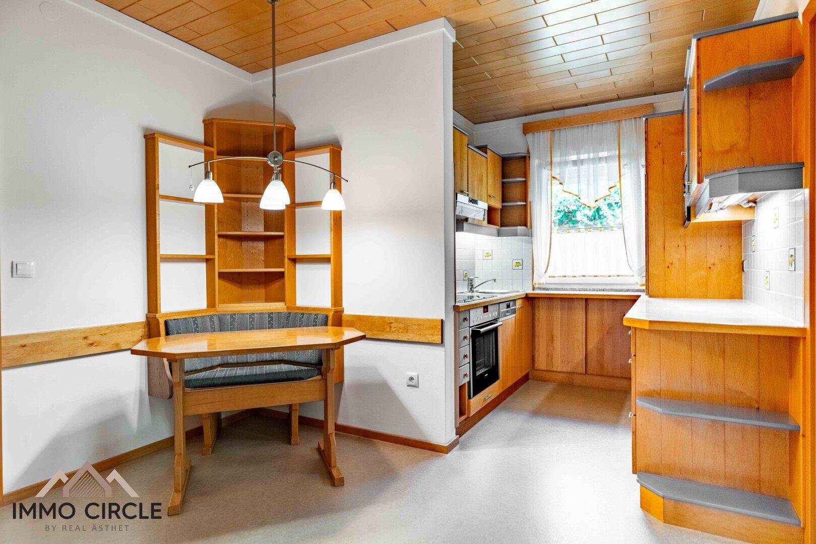 Kleine Küche mit Holzeinbauten, Essbereich und Holzdecke.