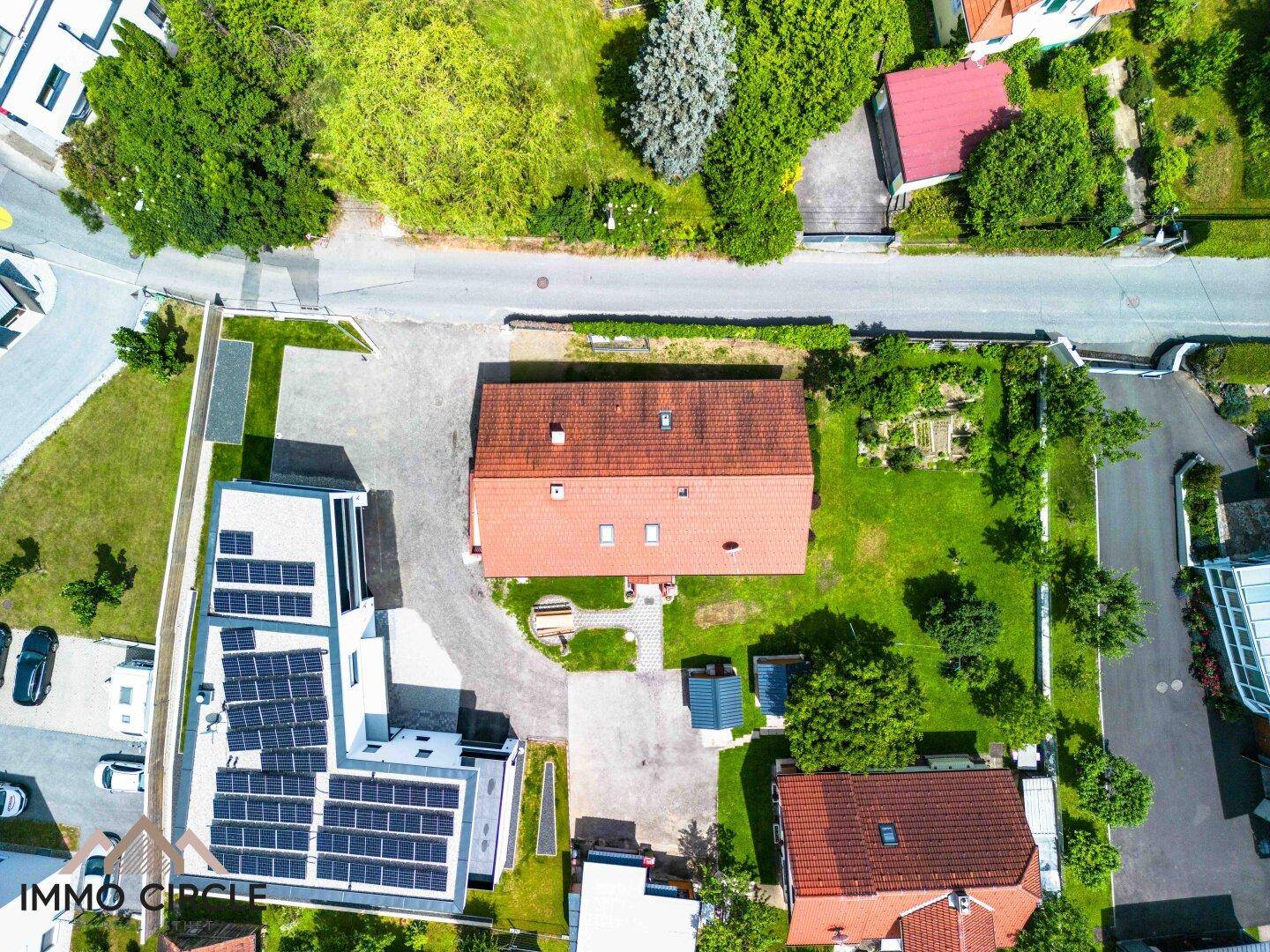 Luftaufnahme des Grundstücks mit Einfamilienhaus, Garten und angrenzenden Gebäuden.