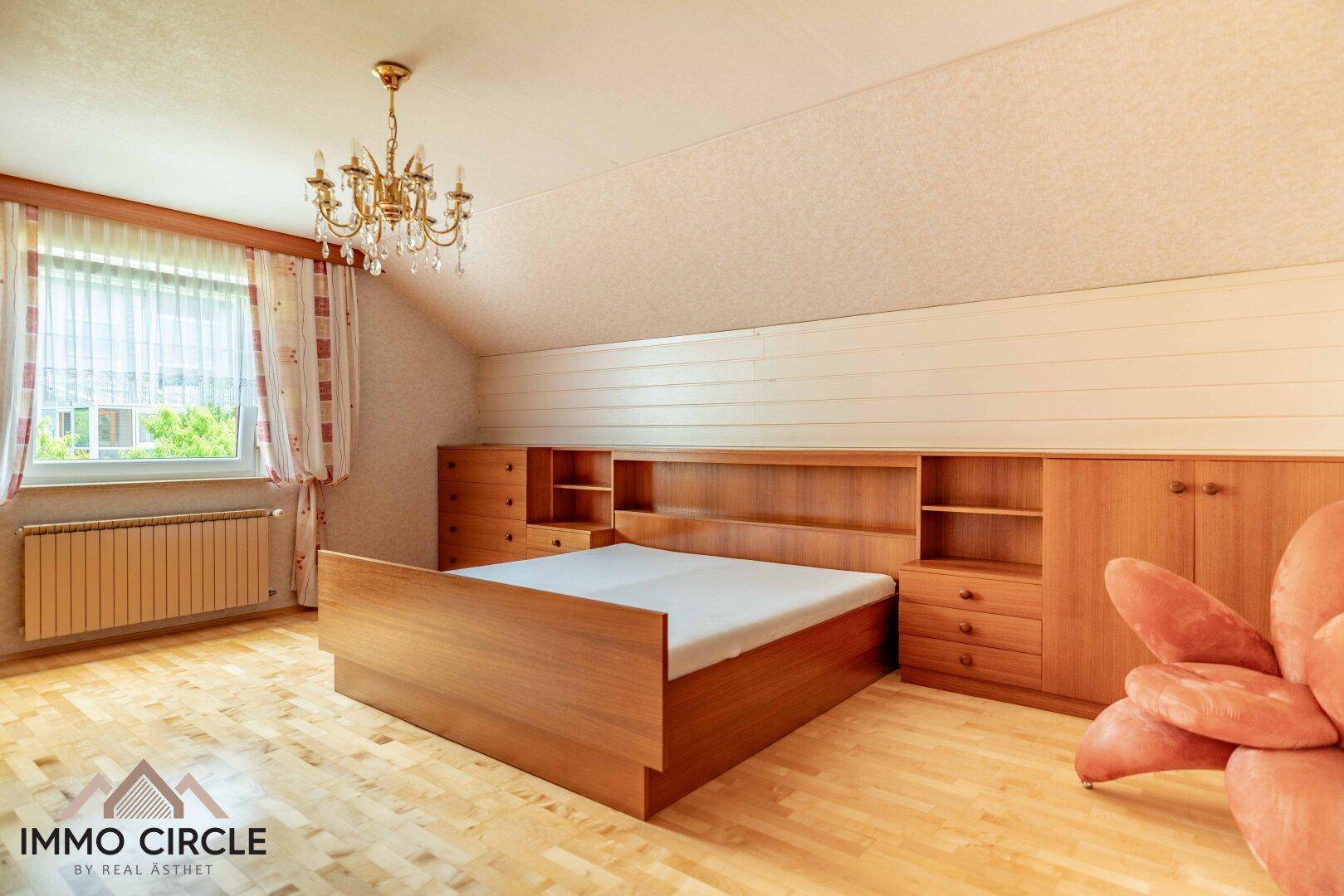 Gemütliches Schlafzimmer mit Holzboden, Einbaubett und Dachschräge.