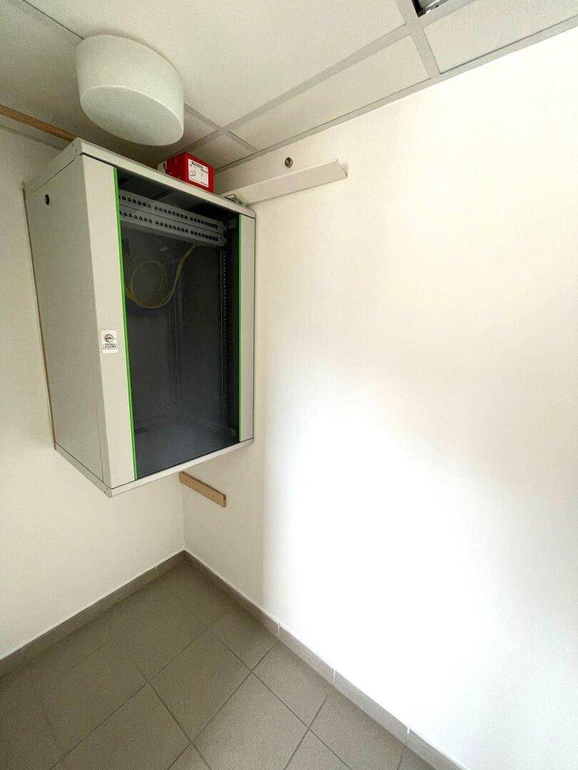 Kleiner Raum mit einem Serverschrank und Fliesenboden, ideal für Technik oder Lagerung von Geräten.
