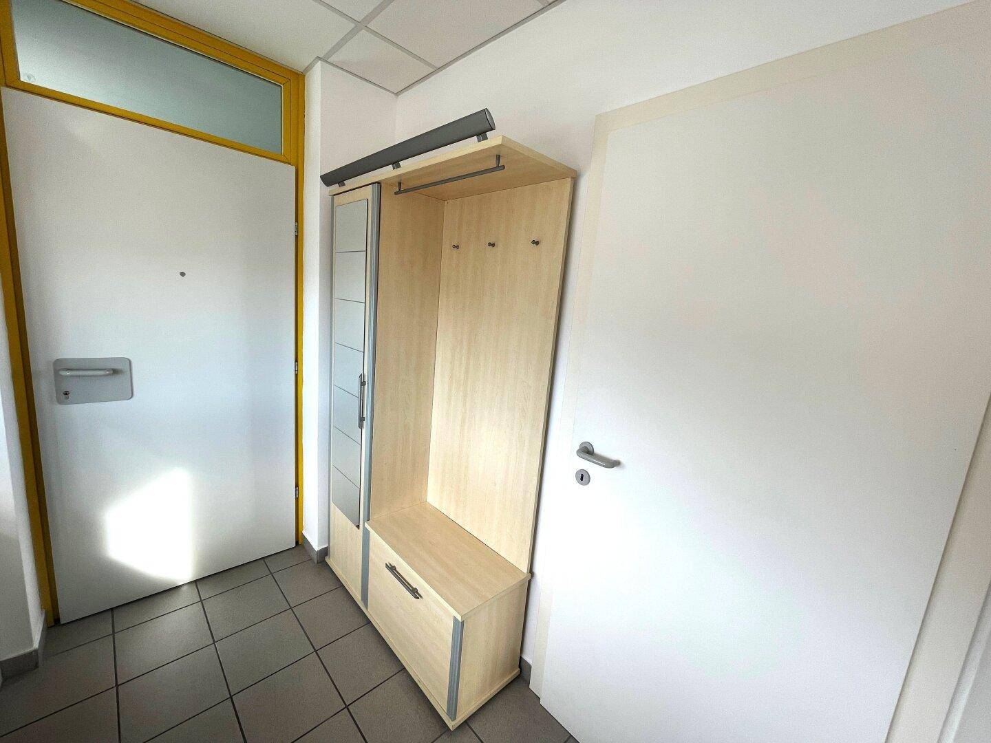 Eingangsbereich mit Garderobenschrank und Fliesenboden, bietet praktischen Stauraum für Kleidung.
