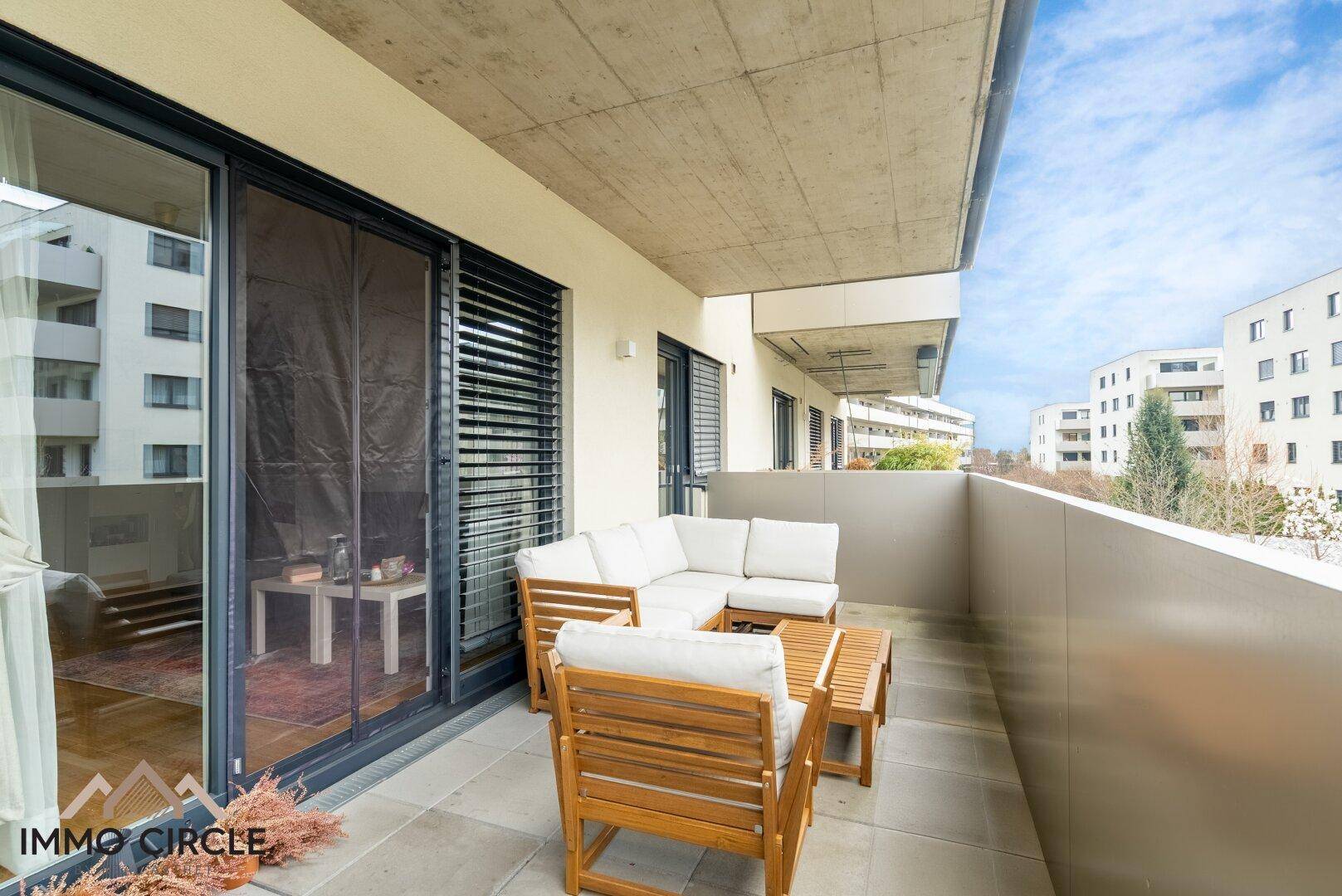 Geräumiger Balkon mit bequemen Gartenmöbeln und Blick auf die umliegenden Gebäude.