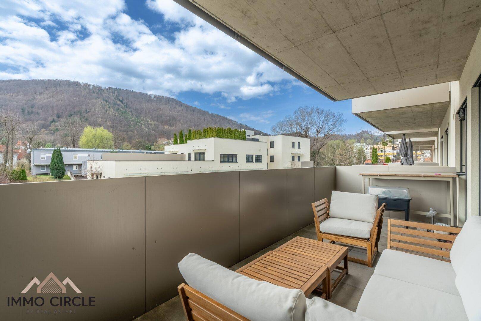Balkon mit Sitzgelegenheiten und weitem Blick auf die bewaldeten Hügel und die Umgebung.