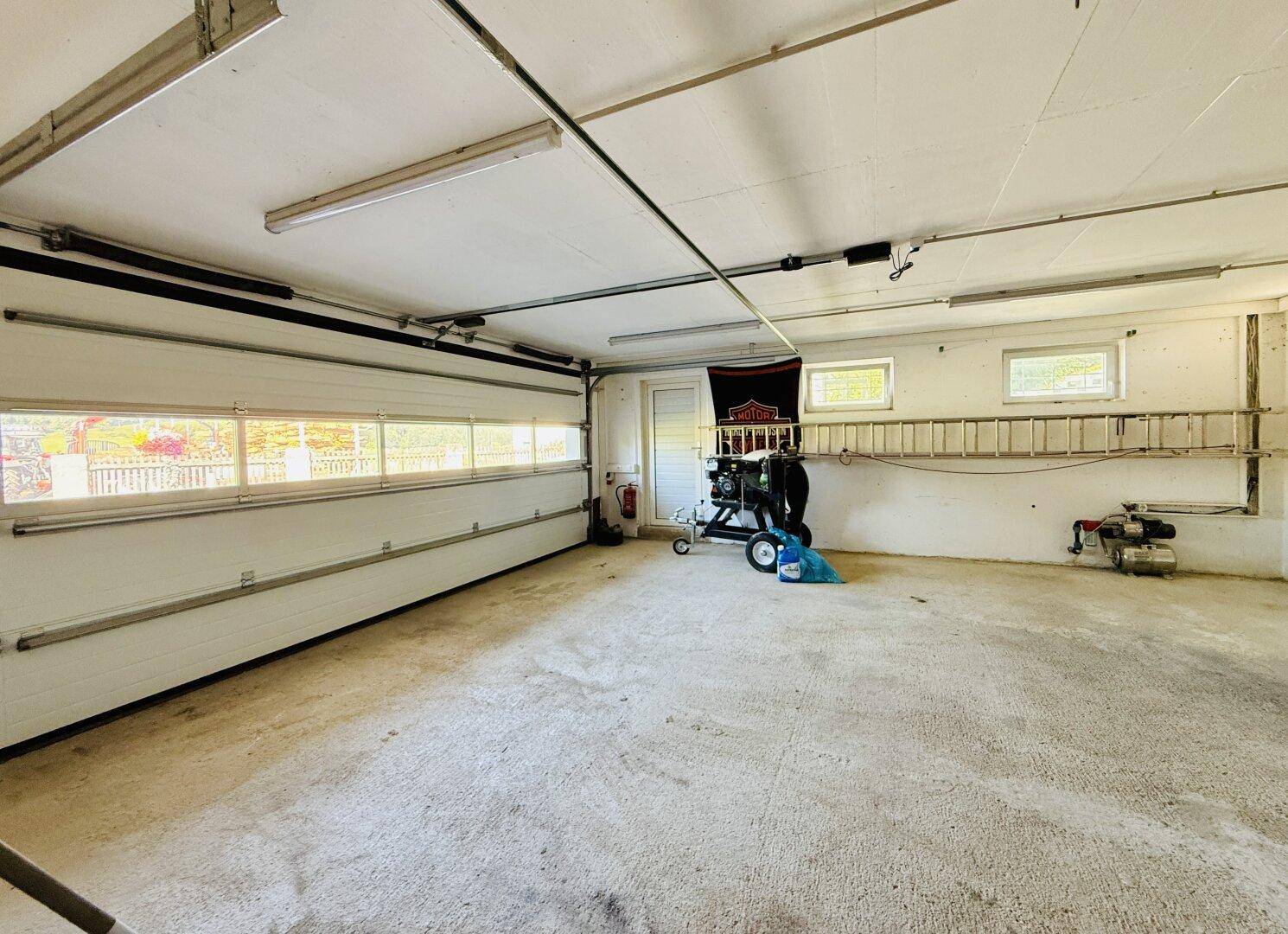 Geräumige Garage mit Rolltor und ausreichend Platz für Fahrzeuge.