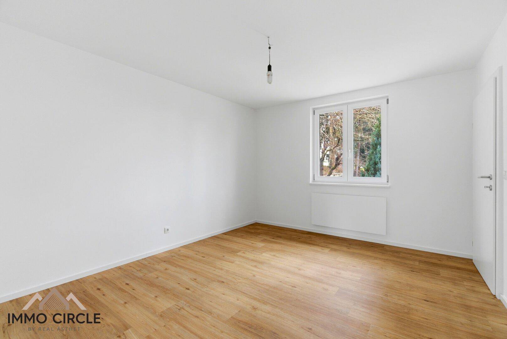 Helles Schlafzimmer mit Holzboden und weiß gestrichenen Wänden, bietet eine ruhige Atmosphäre.