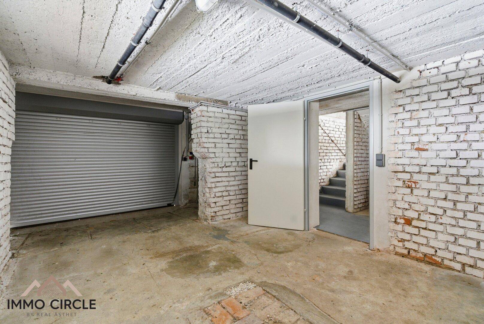 Geräumige Garage im Untergeschoss mit Rolltor und Zugang zum Treppenhaus.
