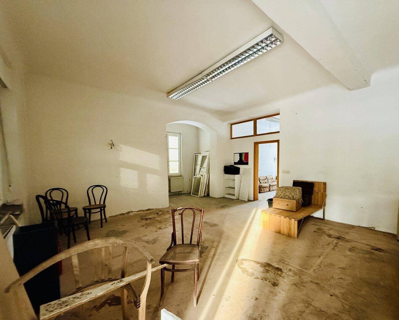 Großer, leerstehender Raum mit hohen Decken und sichtbaren Renovierungsspuren, bereit zur Neugestaltung.
