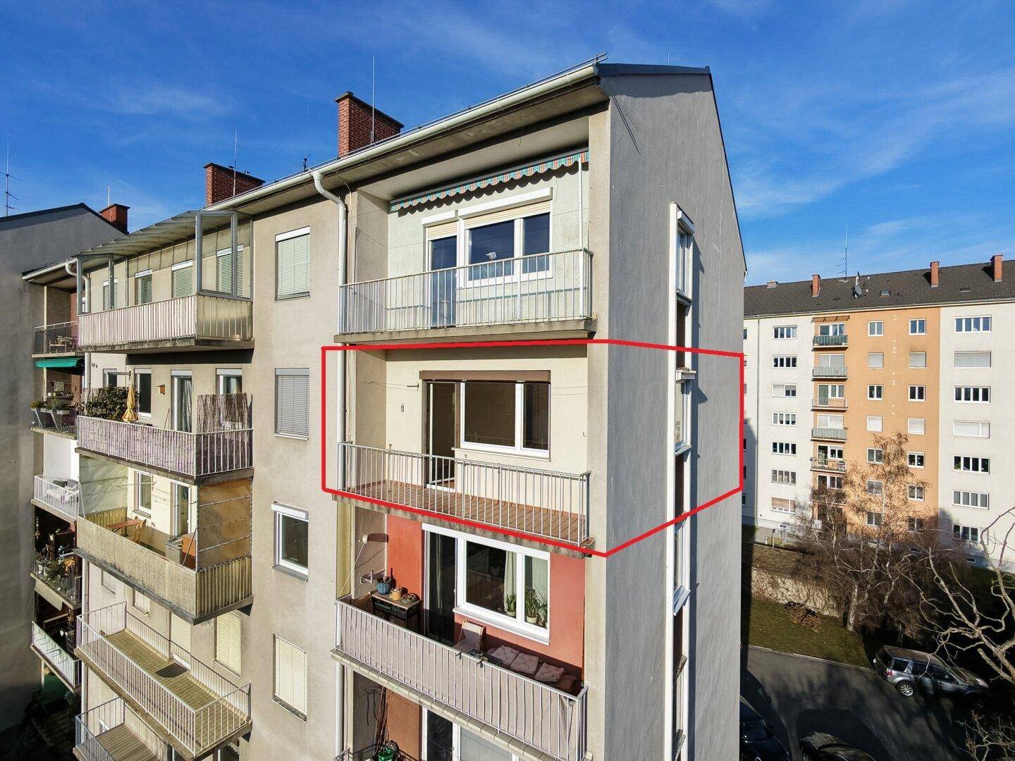 Seitenansicht des Gebäudes mit mehreren Balkonen und umliegender Bebauung.