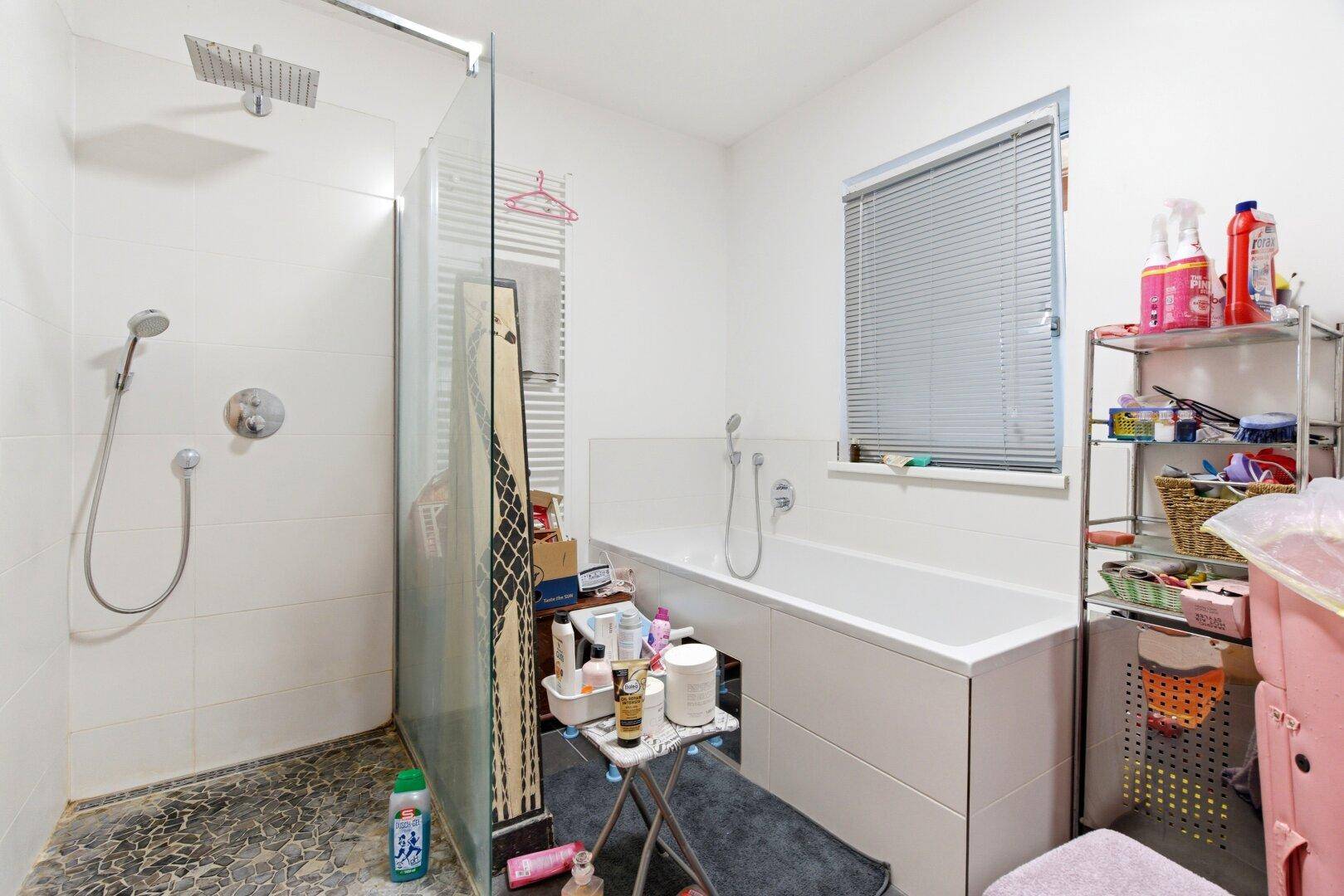 Modernes Badezimmer mit Badewanne, begehbarer Dusche und Fenster.