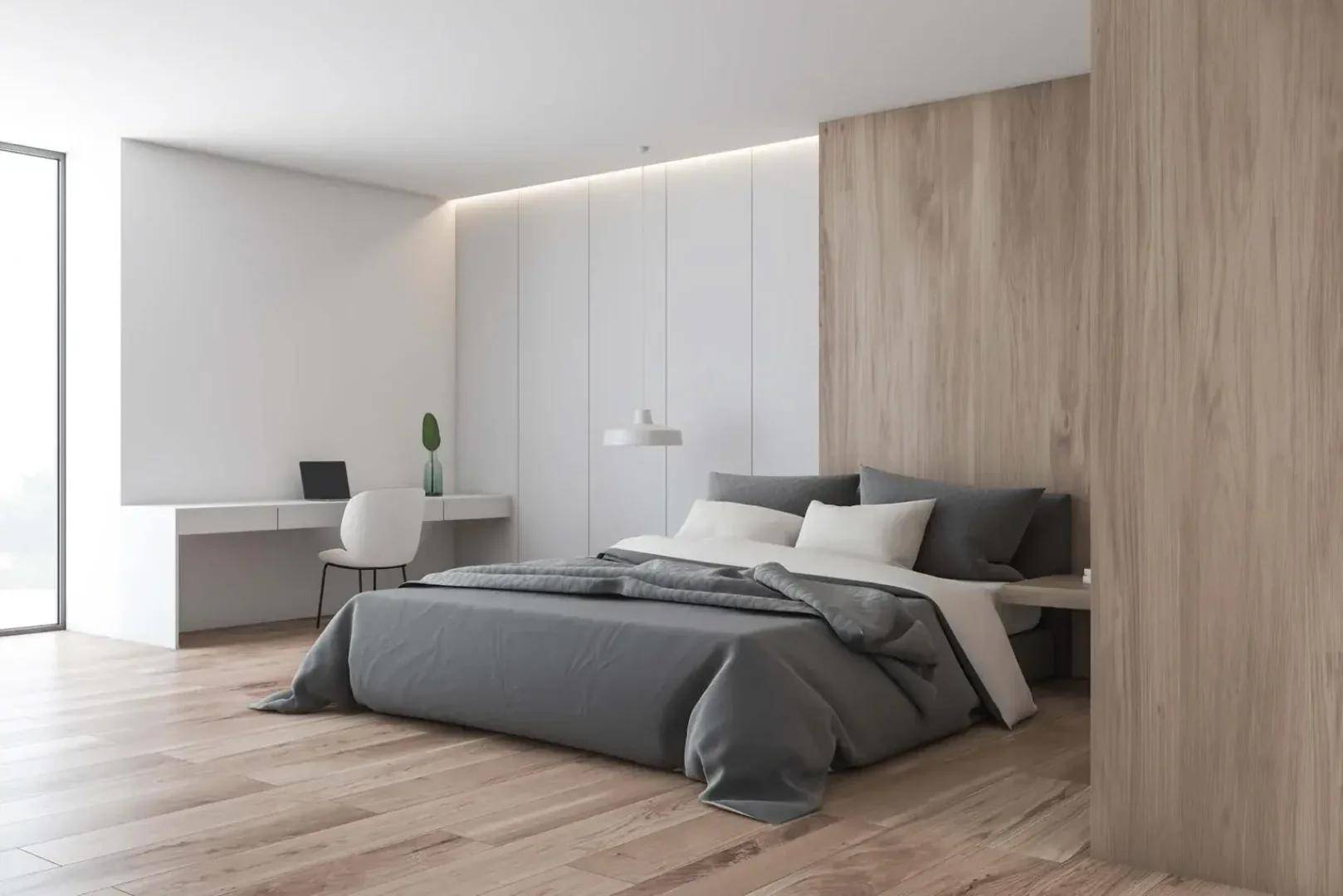 Schlafzimmer mit Holzboden, minimalistischem Design und integriertem Schreibtischbereich.