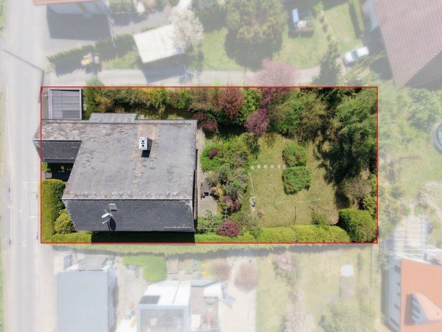 Luftaufnahme des Hauses mit Garten und Grundstücksgrenze, umgeben von viel Grün.