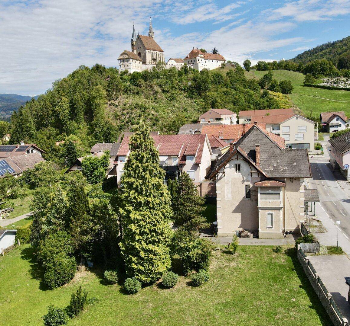 Luftaufnahme des historischen Hauses mit Blick auf die Kirche auf dem Hügel.