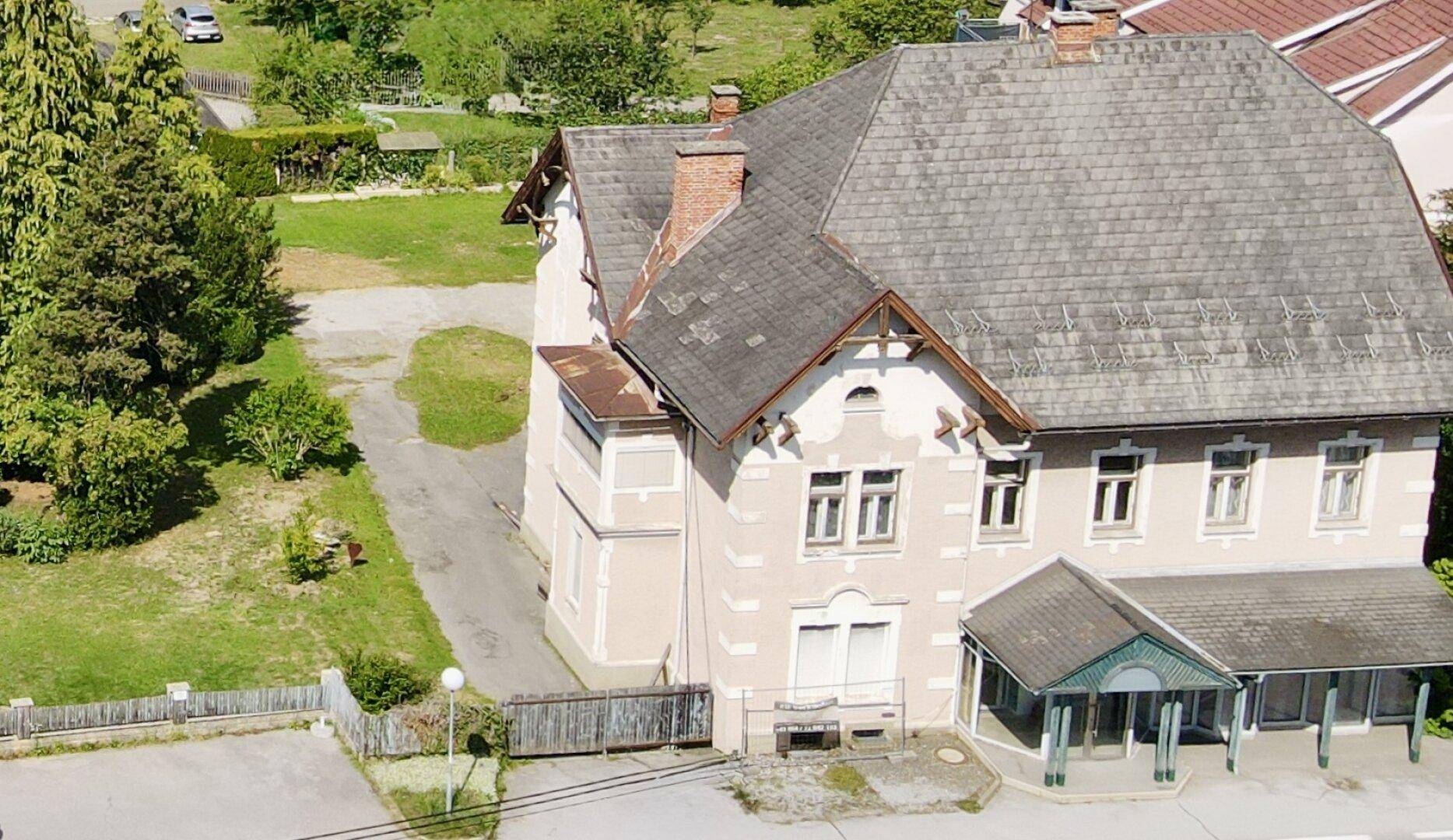 Detailaufnahme der historischen Fassade des Hauses mit Vordach und Zufahrt.