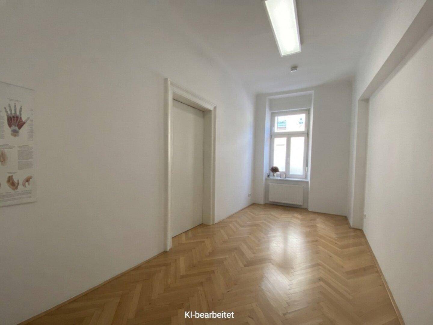 Leerer Raum mit hellem Fischgrätparkett, weißen Wänden und einem Fenster, bereit zur Einrichtung.