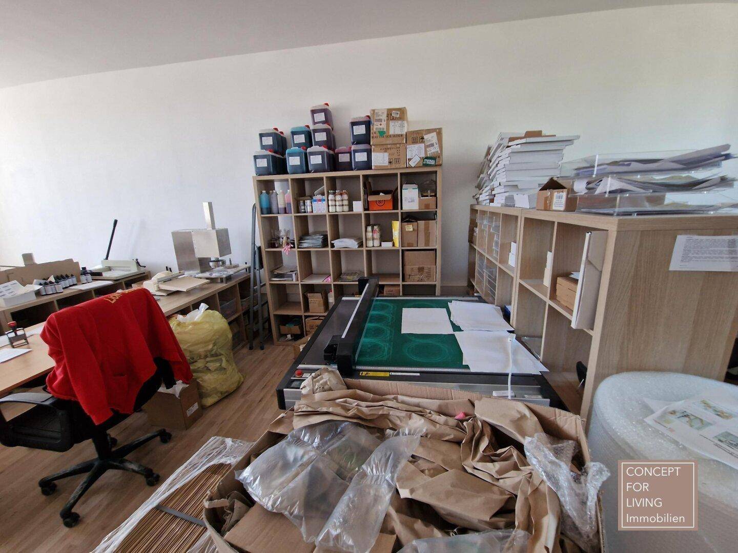 Büro mit Regalen, Arbeitsgeräten und vielen Kartons, die auf eine Renovierung hindeuten.