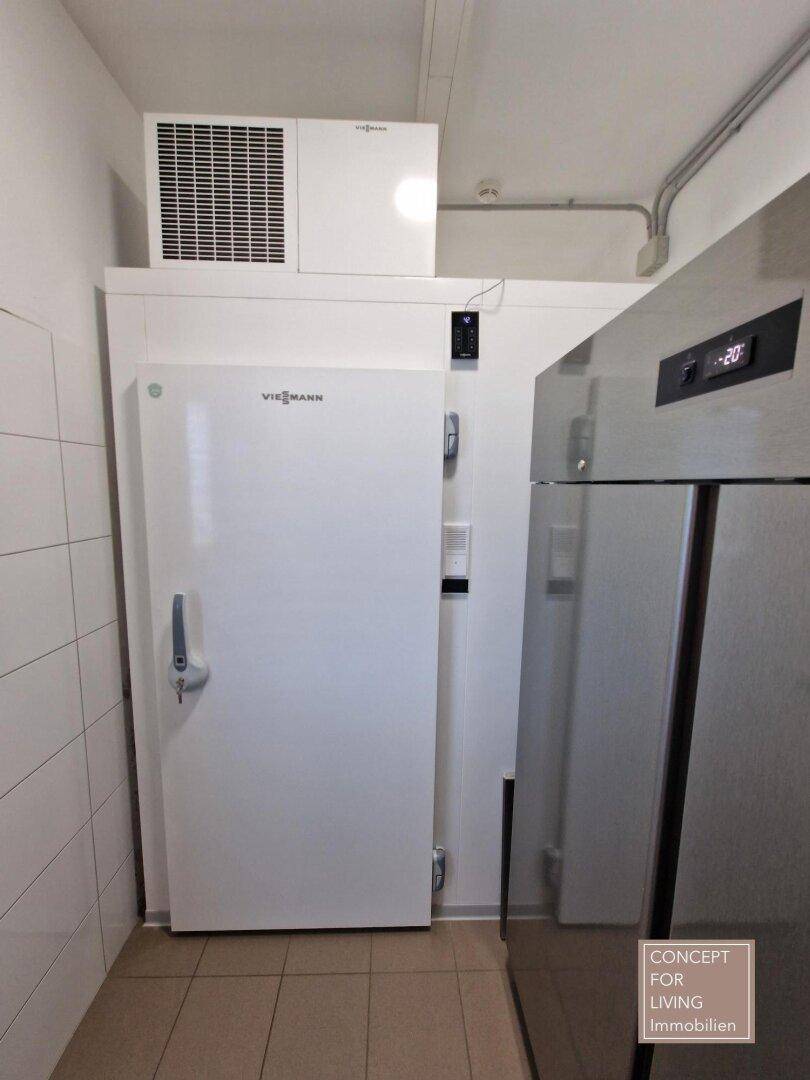 Professioneller Kühlraum mit Viessmann-Kühlsystem und Edelstahl-Kühlschrank in einem gefliesten Raum.