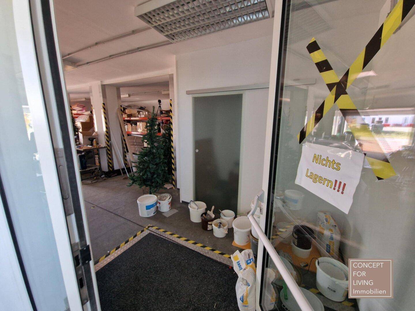 Lagerbereich oder Werkstatt mit verschiedenen Materialien, Eimern und einem Weihnachtsbaum.