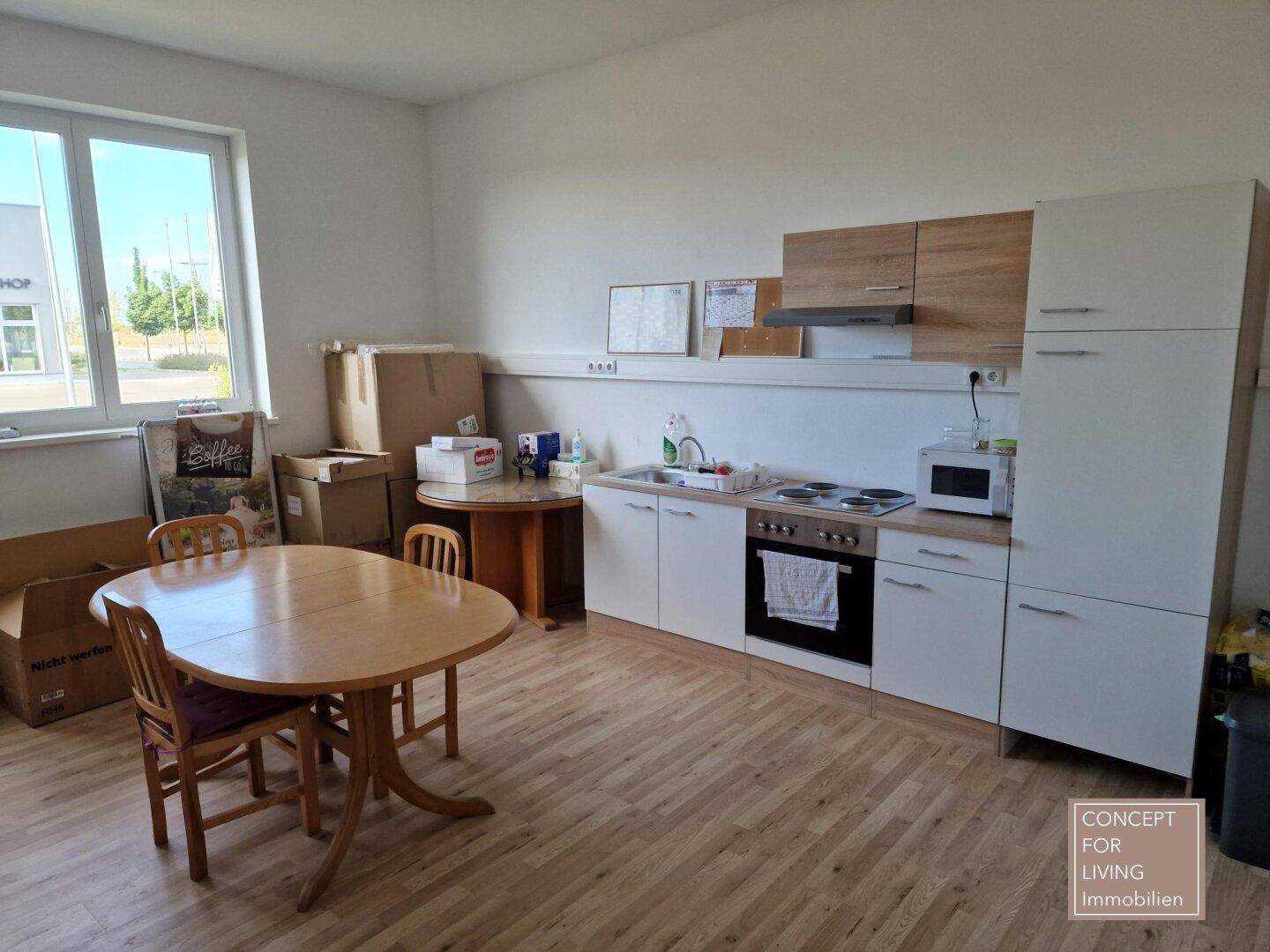 Kleine Einbauküche mit Esstisch und Stühlen, ideal für Pausen, mit Blick nach draußen.