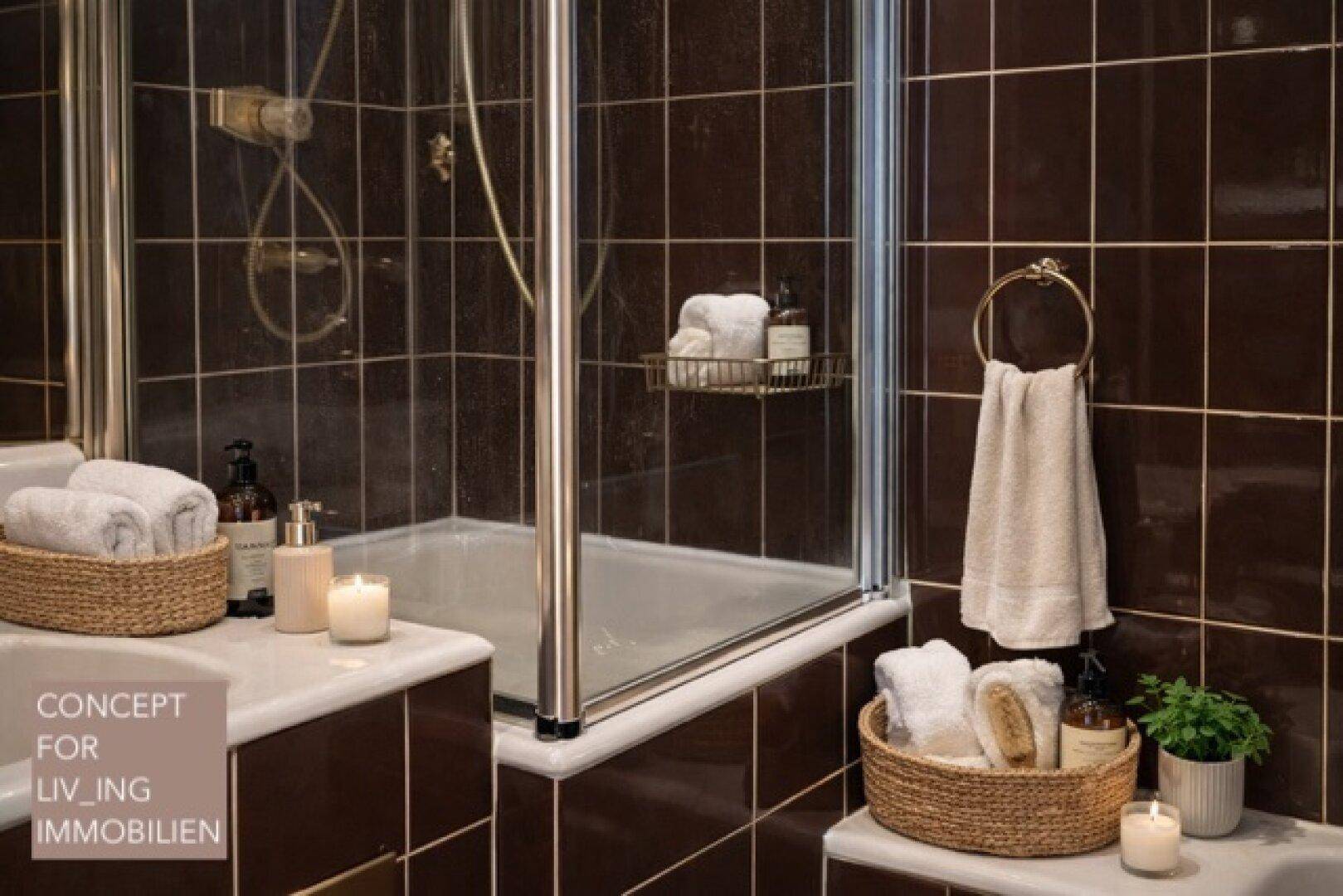 Badezimmer mit braunen Fliesen, Duschkabine und Ablageflächen für Badutensilien.