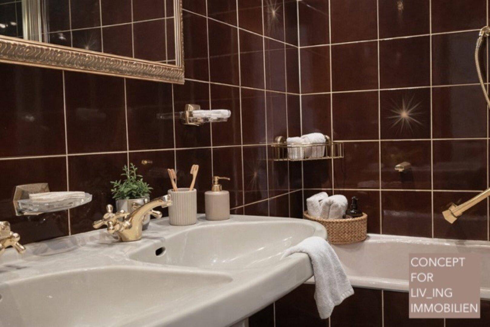 Badezimmer mit braunen Fliesen, Doppelwaschbecken und klassischer Armatur.