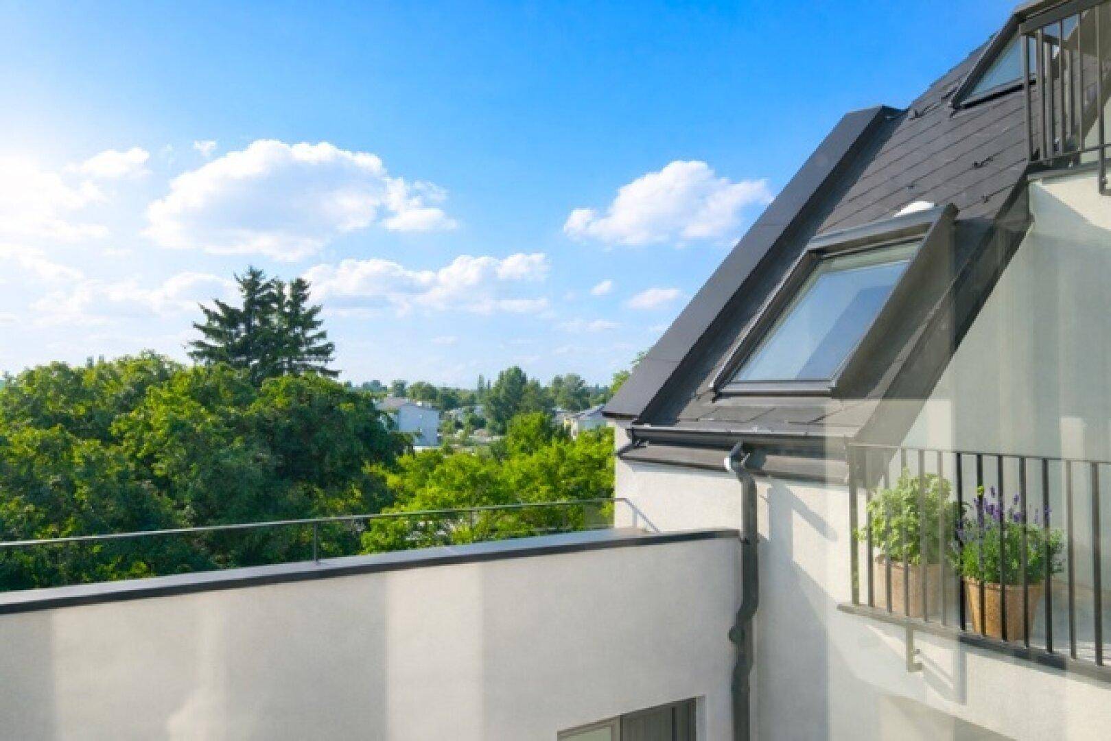 Sonniger Balkon mit Blick ins Grüne und auf die umliegende Landschaft.