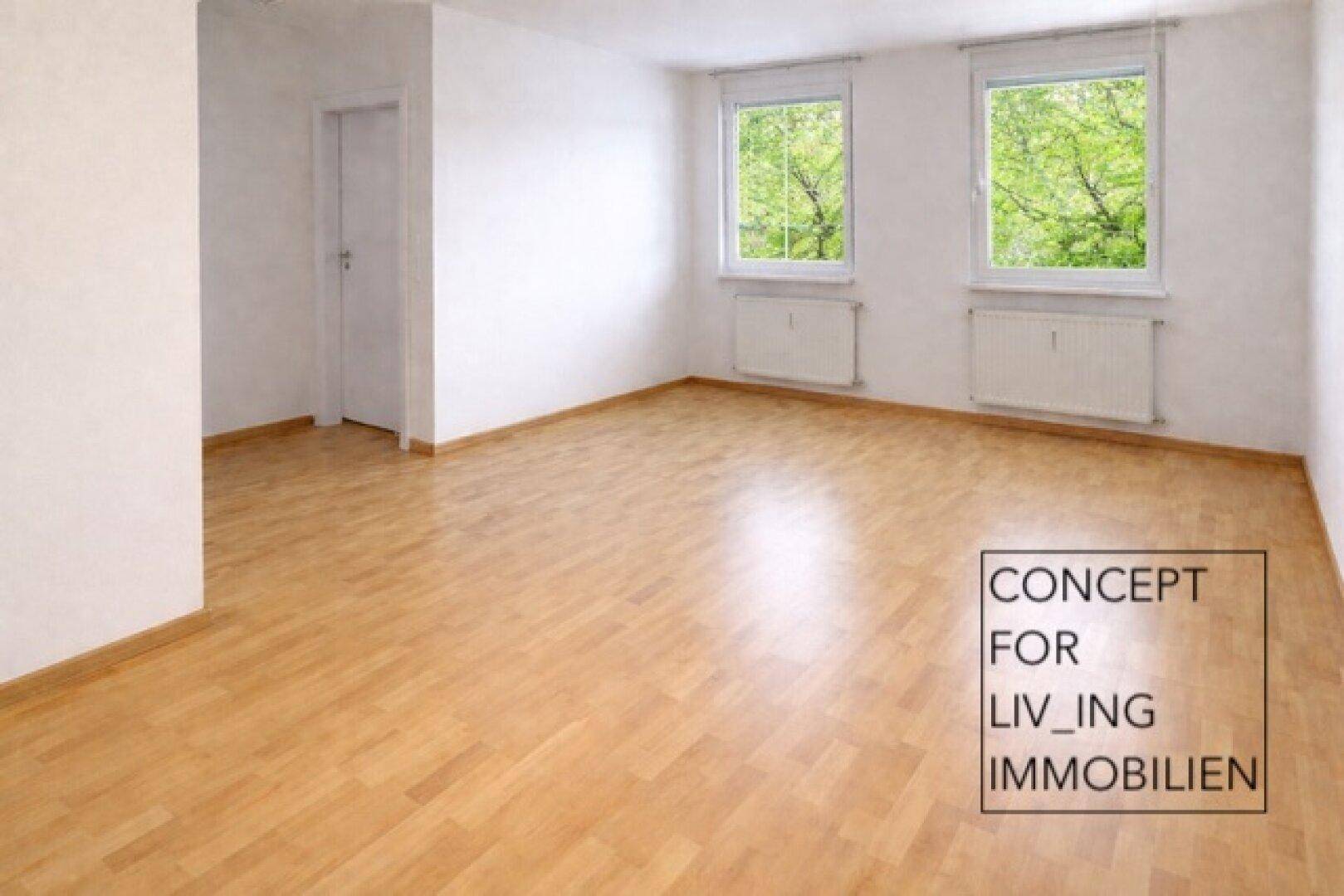 Geräumiges, leeres Zimmer mit Parkettboden und zwei Fenstern, ideal für Wohnzwecke.