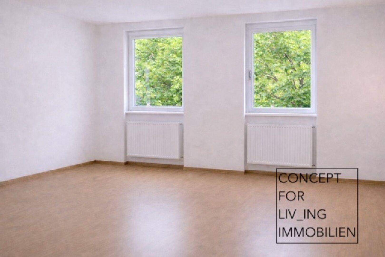 Helles, leeres Zimmer mit Parkettboden und zwei Fenstern, bereit zur individuellen Gestaltung.