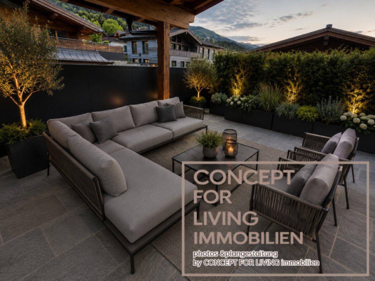Elegante Terrasse mit großzügiger Lounge-Ecke und zusätzlichen Sesseln, umgeben von grünen Pflanzen.