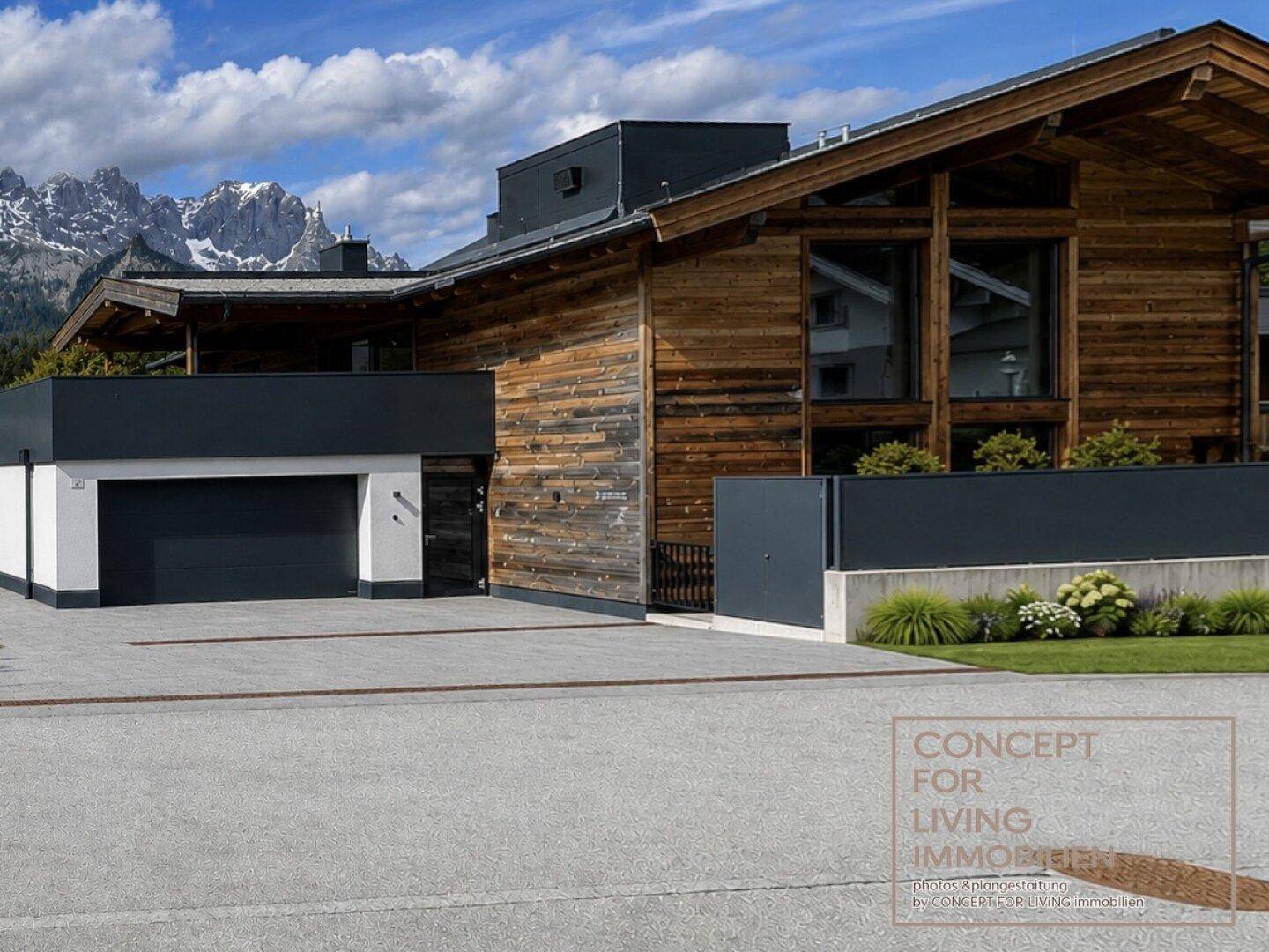 Exklusives Holzhaus mit Doppelgarage und moderner Architektur vor alpiner Bergkulisse.