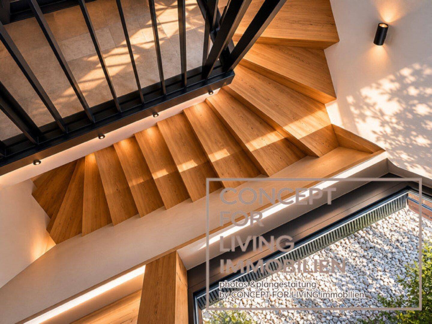 Moderne Holztreppe mit schwarzem Geländer und natürlichem Lichteinfall von außen.