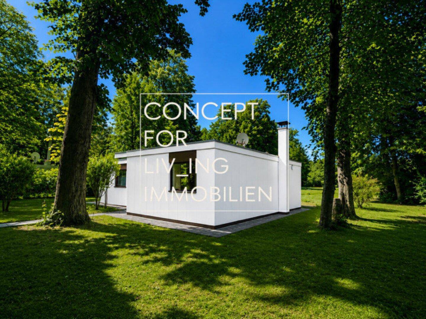 Moderne weiße Villa mit Flachdach, umgeben von einem weitläufigen grünen Garten und hohen Bäumen.