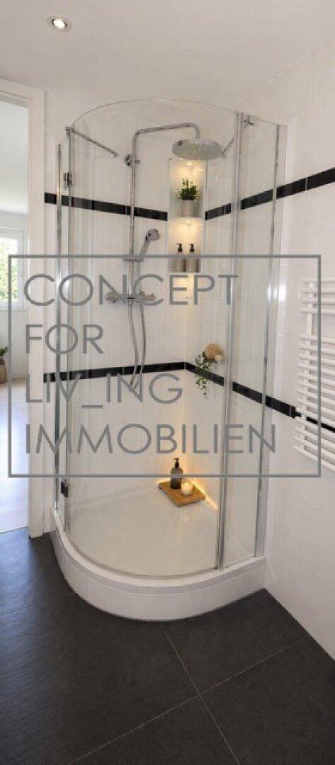 Modernes Badezimmer mit runder Duschkabine, dunklen Fliesen und weißer Wandgestaltung.