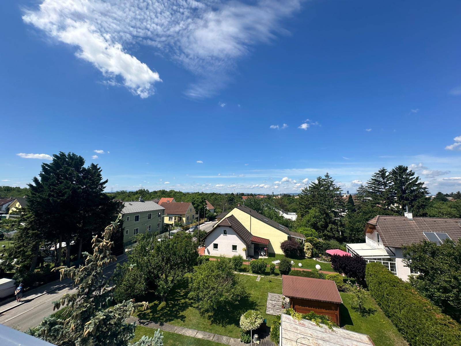 Panoramablick von der Dachterrasse auf eine ruhige Wohnsiedlung mit viel Grün.