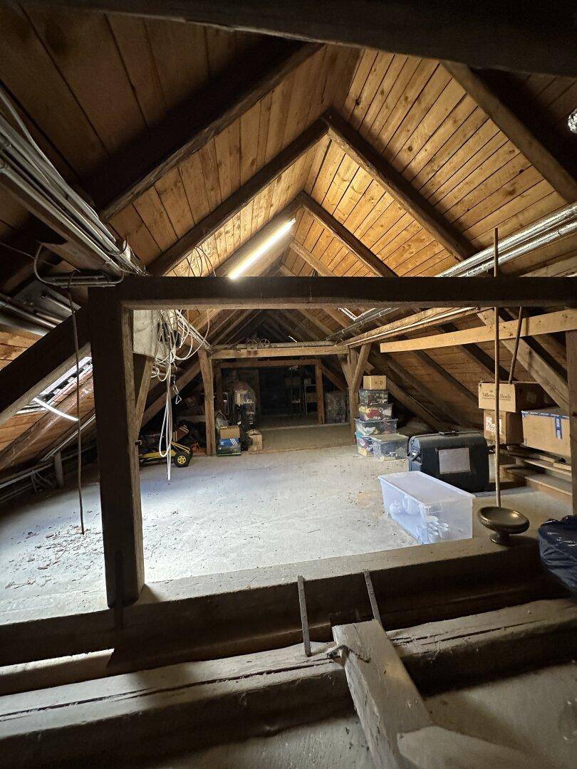 Geräumiger Dachboden mit sichtbaren Holzbalken und viel Stauraum.