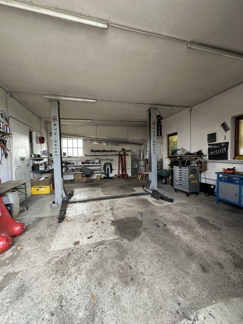 Geräumige Garage oder Werkstatt mit Hebebühne und Betonboden.