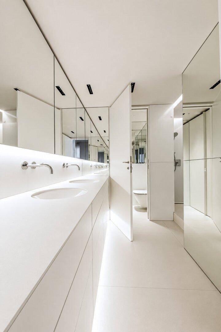 Modernes Badezimmer mit Doppelwaschbecken, großen Spiegeln und minimalistischem Design.