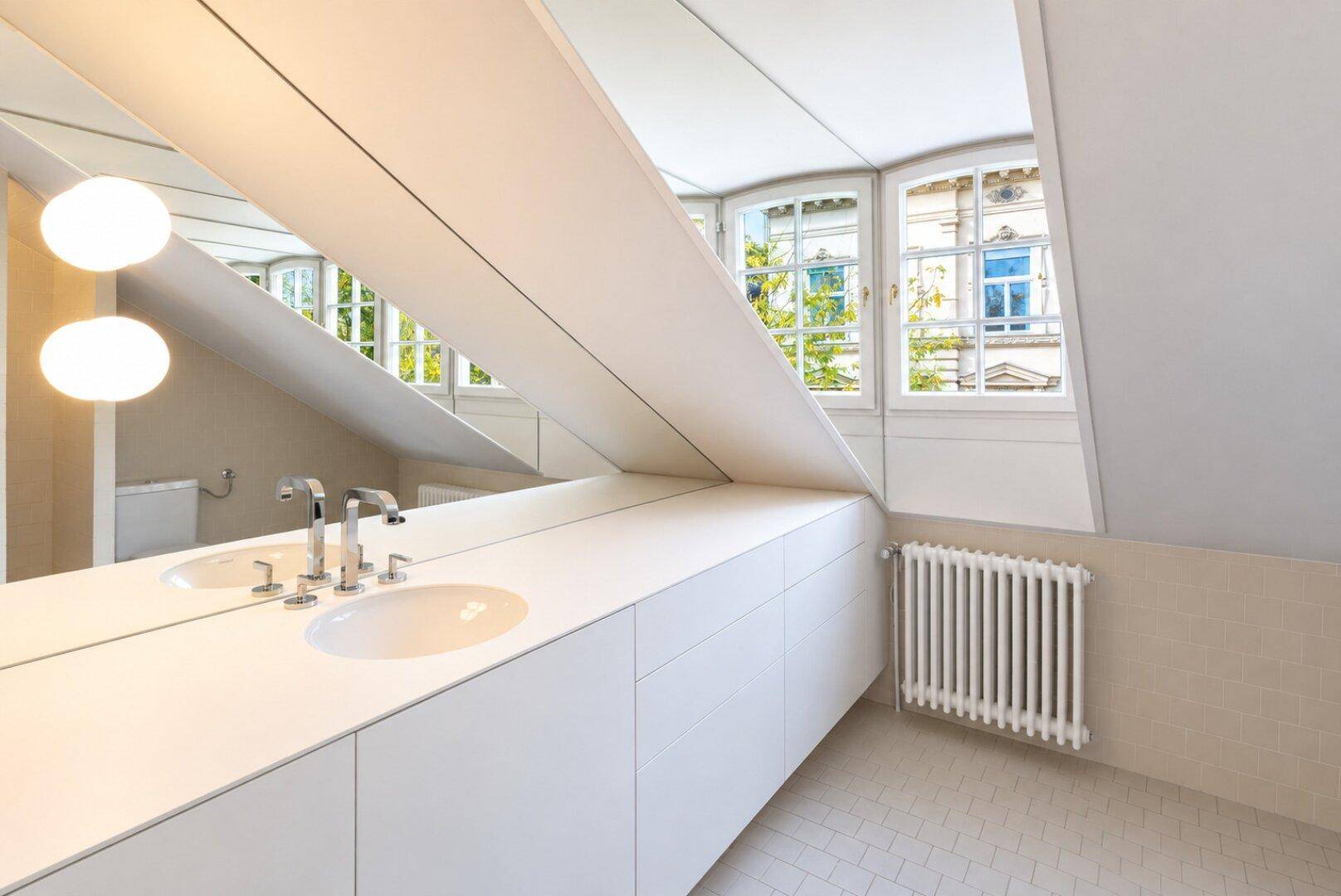 Helles Badezimmer mit Einzelwaschbecken, Heizkörper und Fenster mit Blick nach draußen.