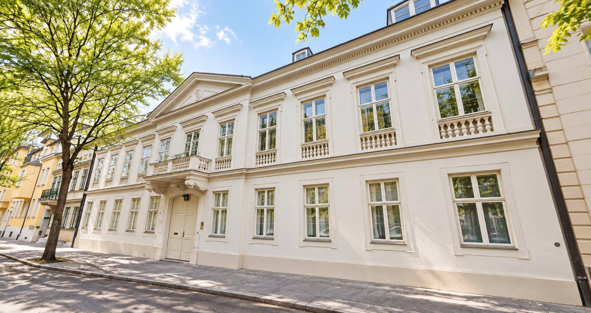 Klassische Fassade eines historischen Gebäudes mit vielen Fenstern und Balkonen.