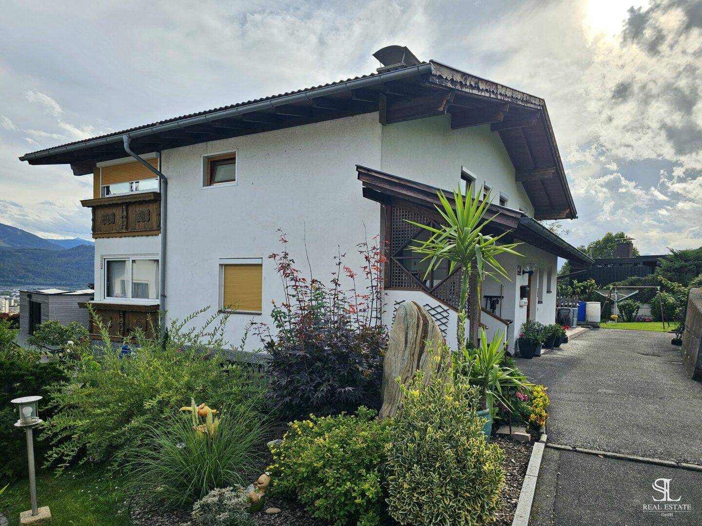 Vorderansicht des Hauses mit einem schön angelegten Vorgarten und Zufahrt.