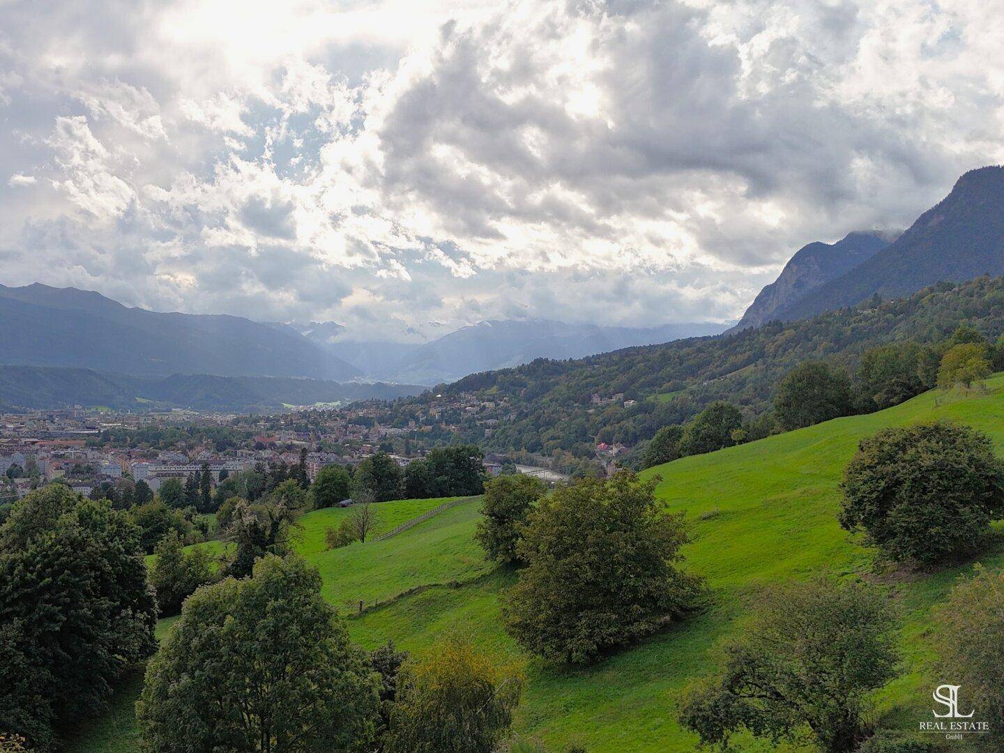Weitläufiger Panoramablick über die grüne Hügellandschaft und die darunter liegende Stadt.