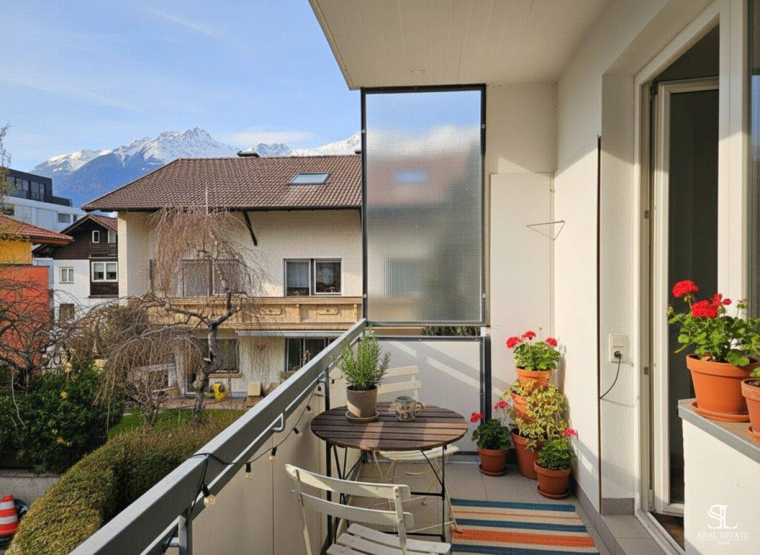 Gemütlicher Balkon mit Sitzgelegenheiten, Pflanzen und einem malerischen Blick auf die Berge.