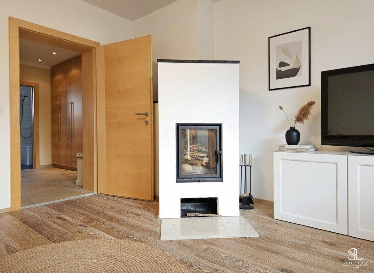 Detailansicht des modernen Kamins im Wohnzimmer mit Holzboden und minimalistischem TV-Möbel.