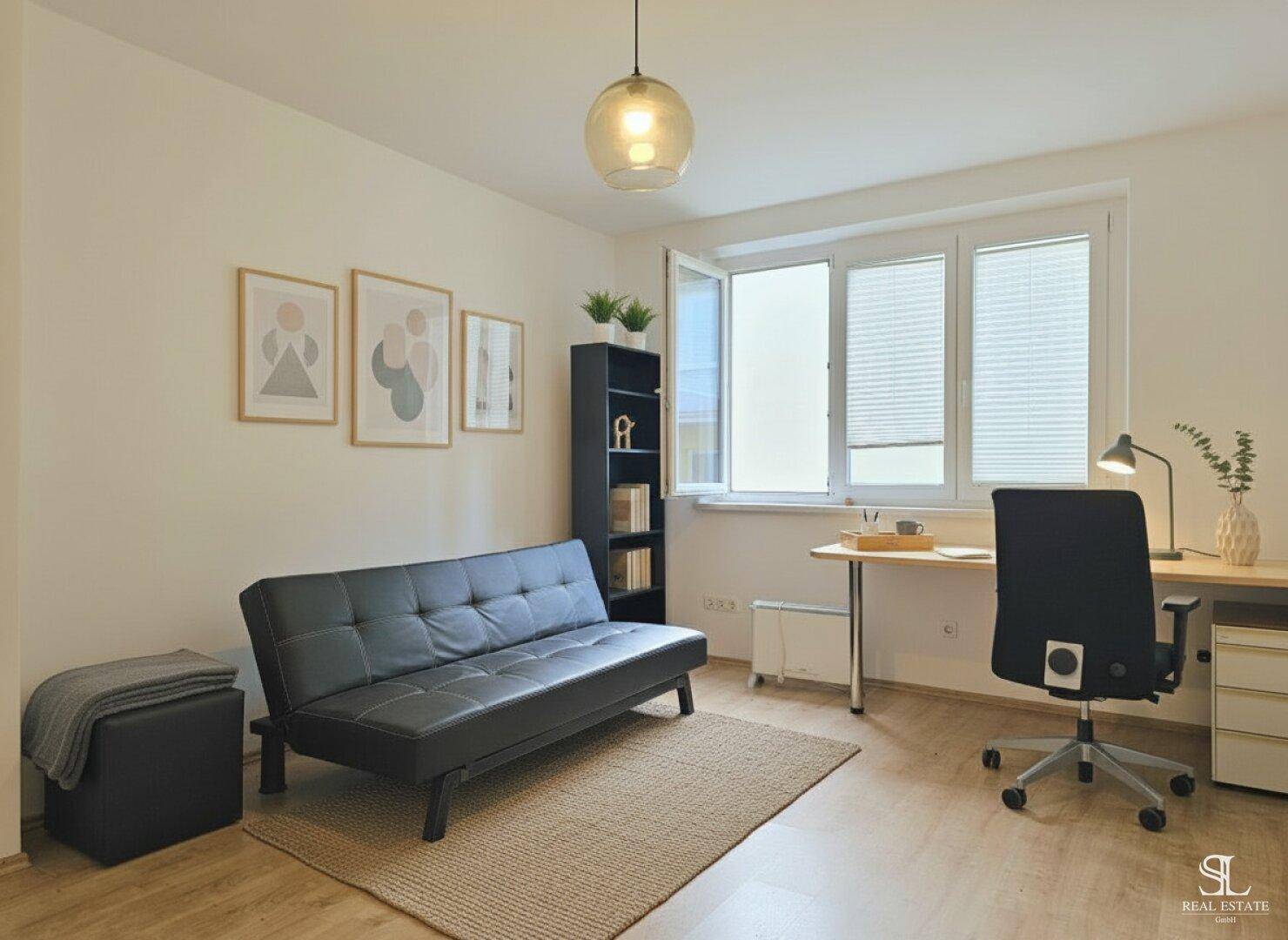 Vielseitiger Raum mit Schlafsofa, Schreibtisch und Bücherregal, ideal als Büro oder Gästezimmer.