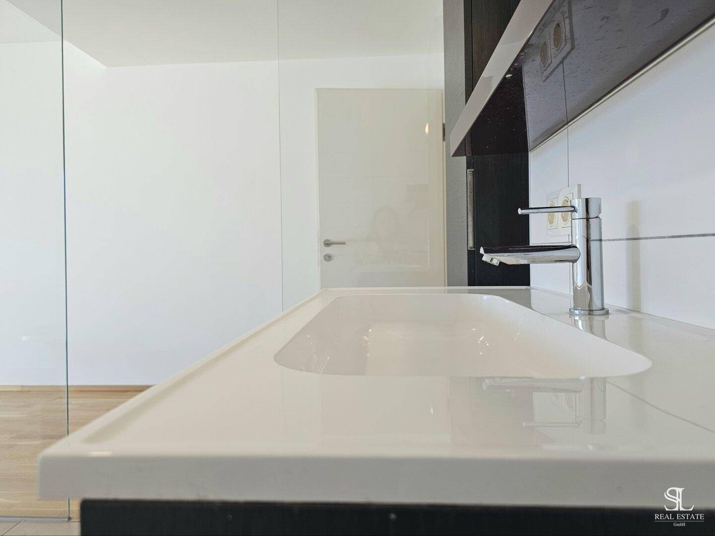 Nahaufnahme eines modernen Waschbeckens mit Armatur und weißen Fliesen im Badezimmer.
