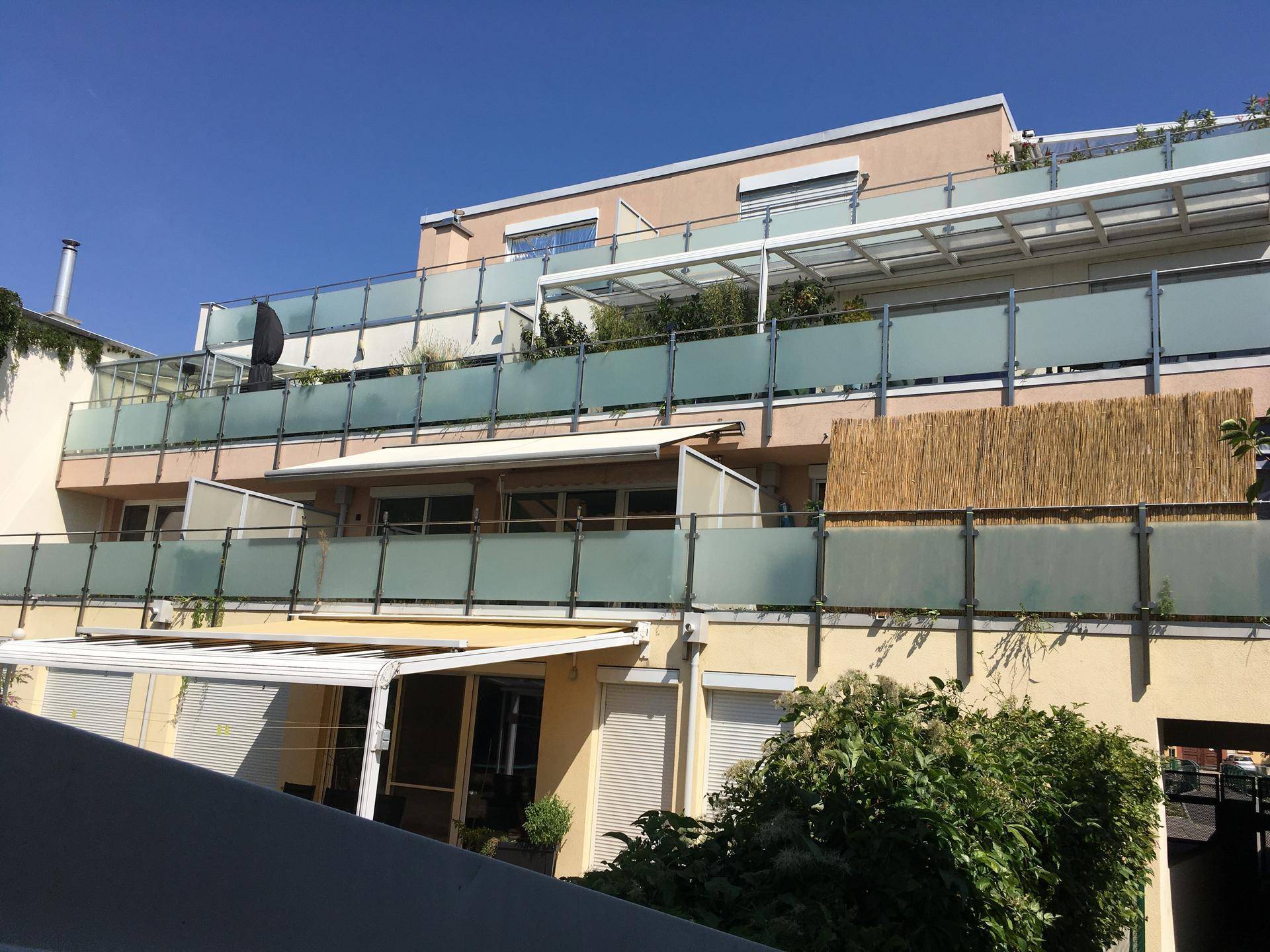 Moderne Gebäudefassade mit mehreren Balkonen und Terrassen.