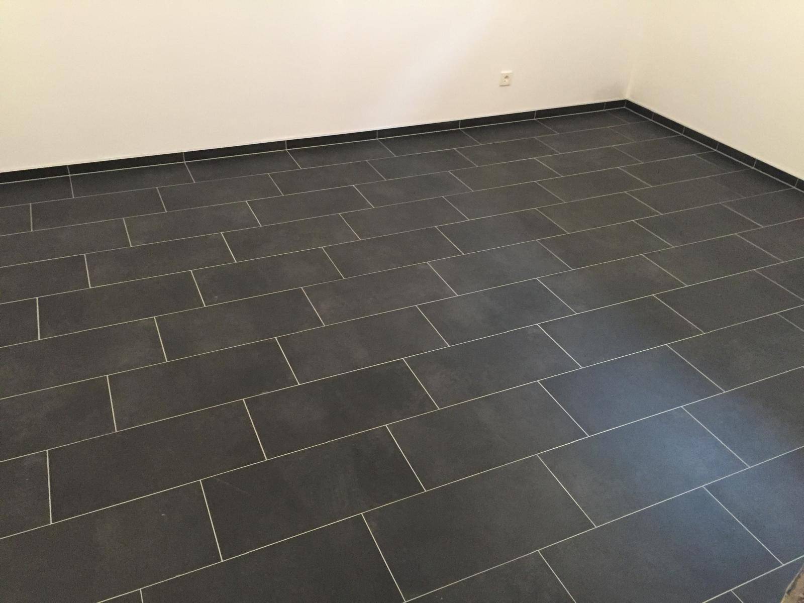 Detailansicht des dunklen Fliesenbodens in einem modernen Wohnraum.